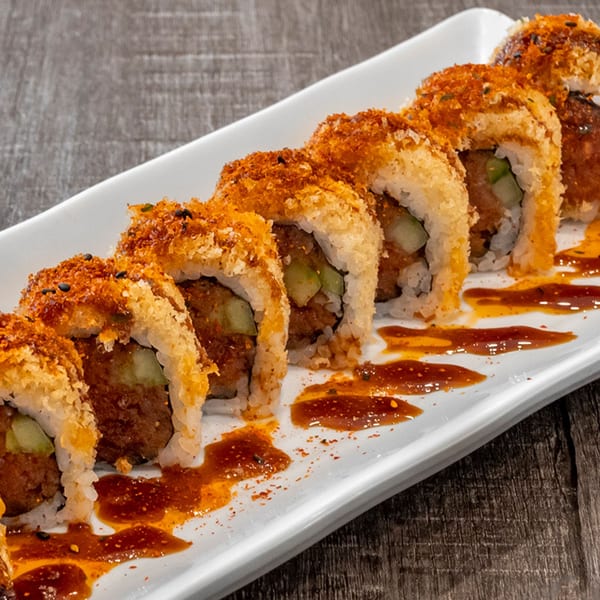 Wazabi Sushi's crispy fried sushi rolls with sauce drizzle on a white plate.