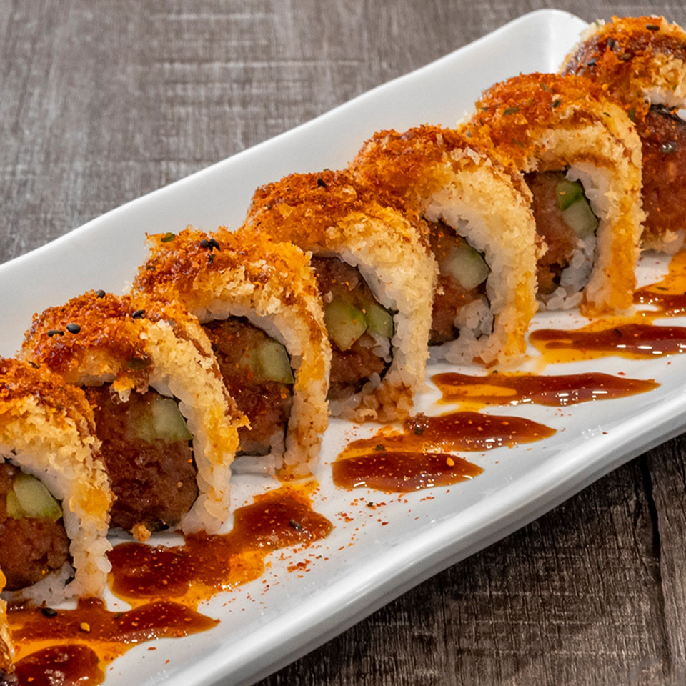 Wazabi Sushi's crispy fried sushi rolls with sauce drizzle on a white plate.