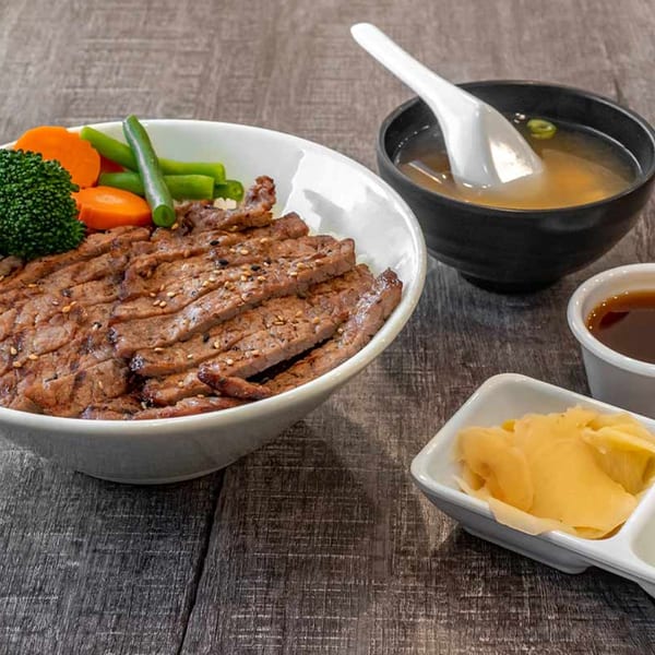 Wazabi Sushi's beef teriyaki bowl with broccoli, carrots, green beans, miso soup, and pickled ginger.