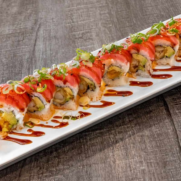 Wazabi Sushi's long white plate of sushi rolls with red tuna, avocado, and green onions.
