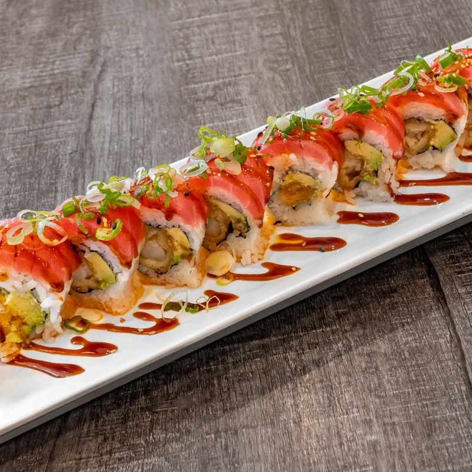 Wazabi Sushi's long white plate of sushi rolls with red tuna, avocado, and green onions.