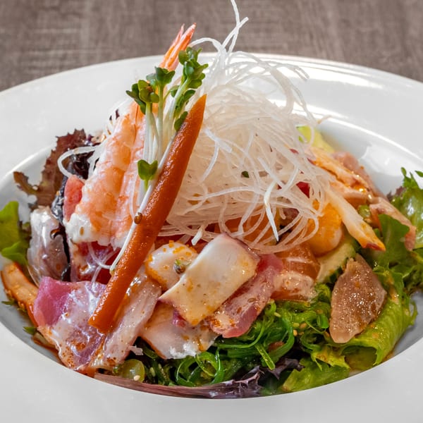 Wazabi Sushi's vibrant seafood salad with shrimp, various fish, seaweed, and shredded daikon radish.
