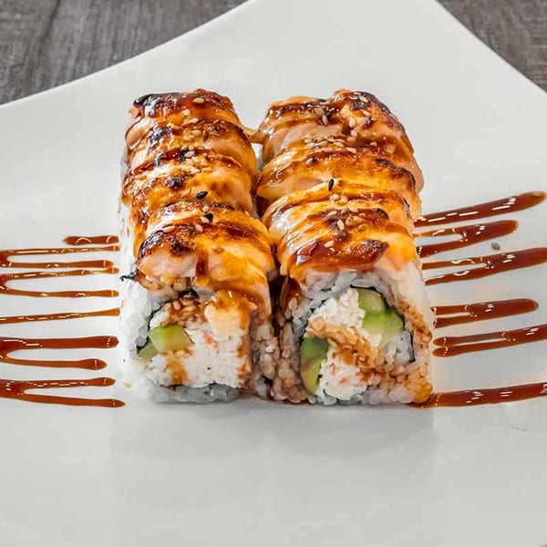 Two rows of Wazabi Sushi rolls with seared salmon, sesame seeds, and a sweet glaze.