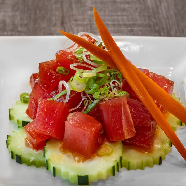 Wazabi Sushi's tuna poke with cucumber slices, green onions, sesame seeds, and carrot sticks.